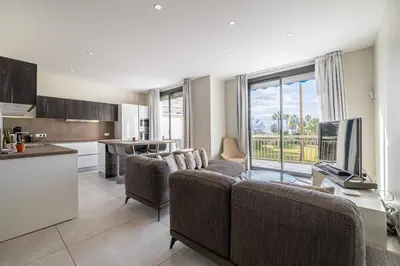 a living room with a couch and a tv and a kitchen at Splendid apartment, Sea view, Parking - Croisette in Cannes