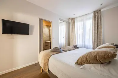 a bedroom with a bed with a flat screen tv on the wall at Splendid apartment, Sea view, Parking - Croisette in Cannes