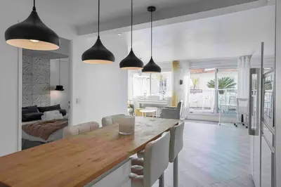 a kitchen and living room with a table and chairs at Cannes Bliss - 12mn à pied du Palais, 5mn plages, clim, terrasse in Cannes