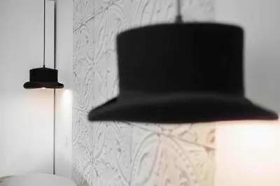 a black hat hanging from a wall next to a lamp at Cannes Bliss - 12mn à pied du Palais, 5mn plages, clim, terrasse in Cannes