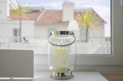 a glass vase sitting on a table in front of a window at Cannes Bliss - 12mn à pied du Palais, 5mn plages, clim, terrasse in Cannes