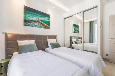 two beds in a hotel room with white walls at Wow this view! 2BR facing Old Port 4th floor Olam Properties in Cannes