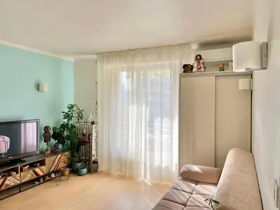 a living room with a couch and a television at Palm Beach apartment in Cannes