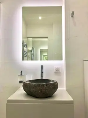 a bathroom with a sink with a mirror at Palm Beach apartment in Cannes