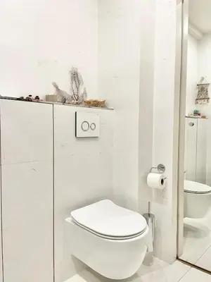 a white bathroom with a toilet and a sink at Palm Beach apartment in Cannes