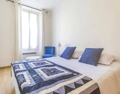 a bedroom with a bed and two blue chairs at NEW Cannes Apt - Amazing Location - La Croisette in Cannes