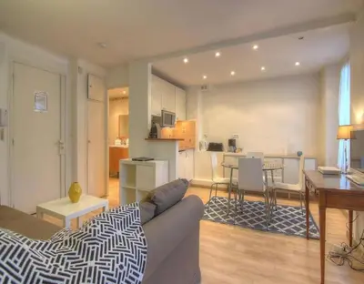 a living room with a couch and a kitchen at NEW Cannes Apt - Amazing Location - La Croisette in Cannes