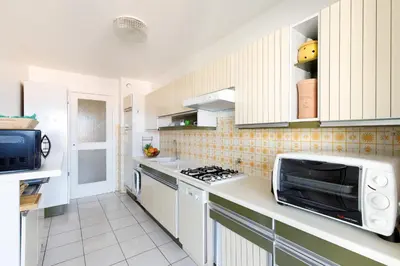 a kitchen with white cabinets and a microwave at Gabriel YourHostHelper in Cannes