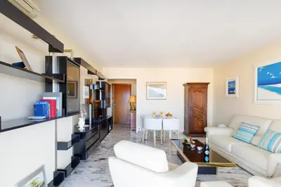 a living room with white furniture and a table at Gabriel YourHostHelper in Cannes