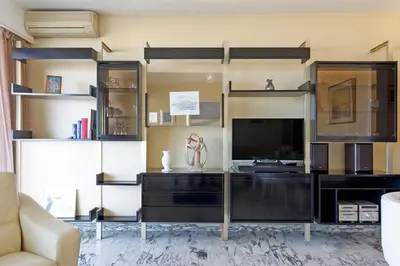 a living room with a large entertainment center with a television at Gabriel YourHostHelper in Cannes