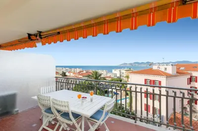 a balcony with a table and chairs and a view at Gabriel YourHostHelper in Cannes