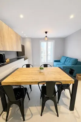 a living room with a table and a blue couch at Suite Suquet plage - 5 places in Cannes