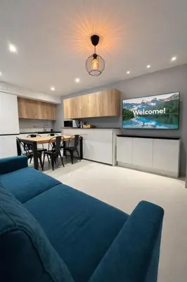 a living room with a blue couch and a television at Suite Suquet plage - 5 places in Cannes