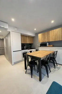 a kitchen with a wooden table and black chairs at Suite Suquet plage - 5 places in Cannes