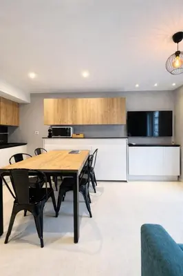 a kitchen and dining room with a wooden table and chairs at Suite Suquet plage - 5 places in Cannes
