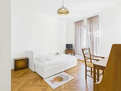 a white bedroom with a bed and a dining room at LE BOURGEOIS avec balcon, somptueux et lumineux, idéalement situé in Cannes
