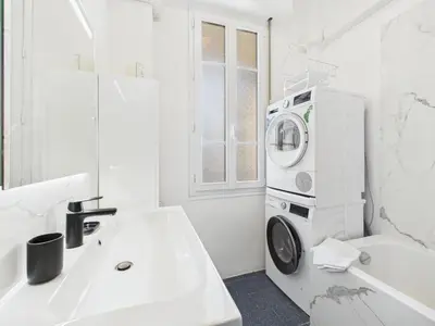 a white bathroom with a washing machine on the wall at LE BOURGEOIS avec balcon, somptueux et lumineux, idéalement situé in Cannes