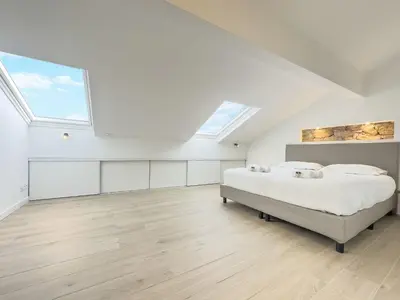 a white bedroom with a bed and a skylight at Le Duplex by Winsome Destination in Cannes