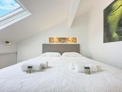 a white bedroom with a large white bed with two pillows at Le Duplex by Winsome Destination in Cannes