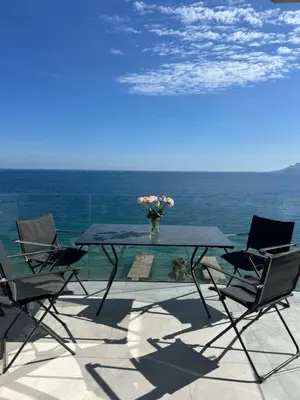 a table with chairs and a vase of flowers on a patio at Sea View Bellamare next Palais Festival in Cannes