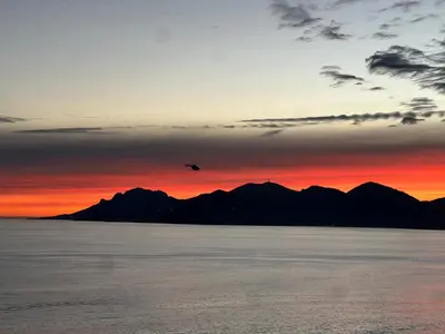 a plane flying over the water at sunset at Sea View Bellamare next Palais Festival in Cannes
