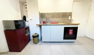 a kitchen with a counter and a dishwasher at Grand Studio Cannes - 5min Plages & Gare & Palais des Festivals - Climatisation in Cannes