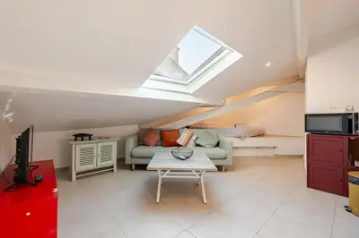 a living room with a couch and a window at Grand Studio Cannes - 5min Plages & Gare & Palais des Festivals - Climatisation in Cannes