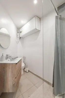 a bathroom with a sink and a mirror and a shower at Grand Studio Cannes - 5min Plages & Gare & Palais des Festivals - Climatisation in Cannes
