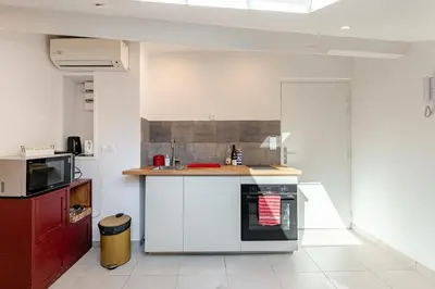 a kitchen with a counter and a stove top oven at Grand Studio Cannes - 5min Plages & Gare & Palais des Festivals - Climatisation in Cannes
