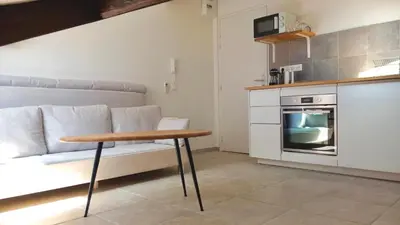 a kitchen with a couch and a table in a room at Petit Studio Cannes - 5min Plages & Gare & Palais des Festivals - Climatisation in Cannes