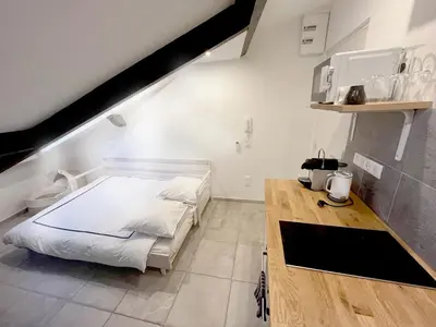 a bedroom with a white bed and a wooden desk at Petit Studio Cannes - 5min Plages & Gare & Palais des Festivals - Climatisation in Cannes
