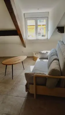 a living room with a couch and a table at Petit Studio Cannes - 5min Plages & Gare & Palais des Festivals - Climatisation in Cannes