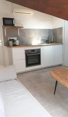 a small kitchen with a stove and a table at Petit Studio Cannes - 5min Plages & Gare & Palais des Festivals - Climatisation in Cannes
