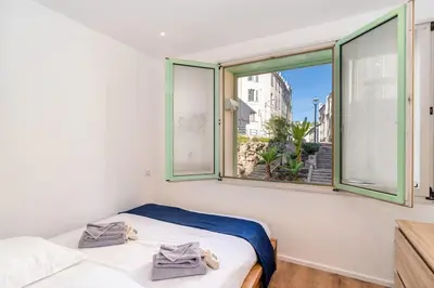 a bedroom with two beds and a large window at Cannes 3 pièces Rénové 2023 Vieux Port et Palais Olam Properties in Cannes