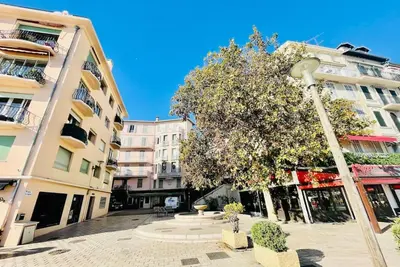 a street light next to a building with a tree at Cannes 3 pièces Rénové 2023 Vieux Port et Palais Olam Properties in Cannes