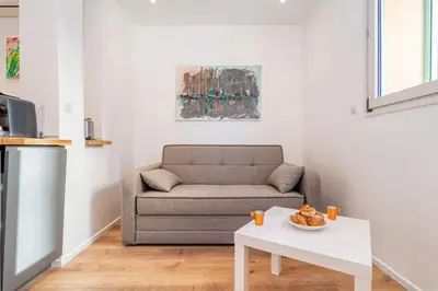 a living room with a couch and a table at Cannes 3 pièces Rénové 2023 Vieux Port et Palais Olam Properties in Cannes