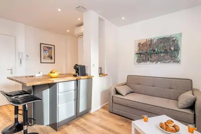 a living room with a couch and a table at Cannes 3 pièces Rénové 2023 Vieux Port et Palais Olam Properties in Cannes