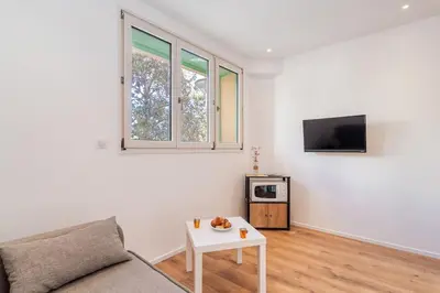 a living room with a couch and a table at Cannes 3 pièces Rénové 2023 Vieux Port et Palais Olam Properties in Cannes