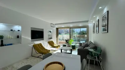 a living room with a couch and chairs and a tv at A010-Superbe appartement refait à neuf proche Croisette in Cannes