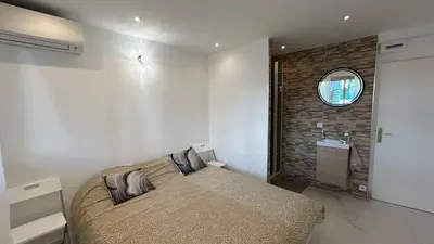 a bedroom with a bed and a bathroom with a sink at A010-Superbe appartement refait à neuf proche Croisette in Cannes