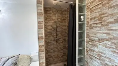 a shower in a room with a brick wall at A010-Superbe appartement refait à neuf proche Croisette in Cannes