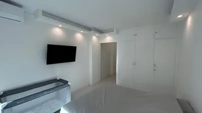 a white room with a bed and a tv on the wall at A010-Superbe appartement refait à neuf proche Croisette in Cannes