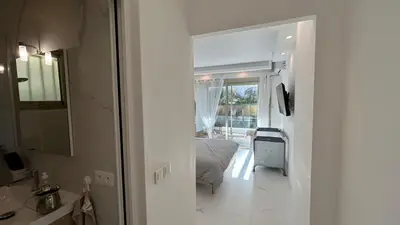 a white room with a bed and a bathroom at A010-Superbe appartement refait à neuf proche Croisette in Cannes