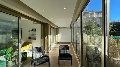 a room with glass doors and chairs and a balcony at A010-Superbe appartement refait à neuf proche Croisette in Cannes