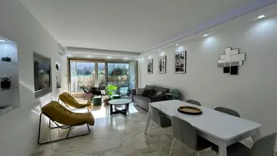 a living room with a couch and a table and chairs at A010-Superbe appartement refait à neuf proche Croisette in Cannes