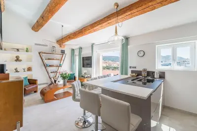 a kitchen with a large island with a sink and chairs at Facing old Port of Cannes Duplex WOW this view Olam Properties in Cannes