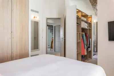 a bedroom with a white bed and a closet at Facing old Port of Cannes Duplex WOW this view Olam Properties in Cannes