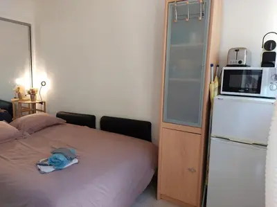a bedroom with a bed with a microwave and a refrigerator at Studette Pointe Croisette - Axelle Loc'Appart in Cannes