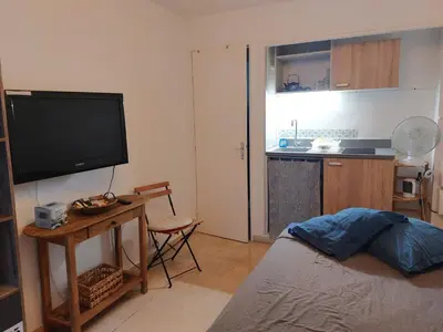 a living room with a bed and a flat screen tv at Studette Pointe Croisette - Axelle Loc'Appart in Cannes
