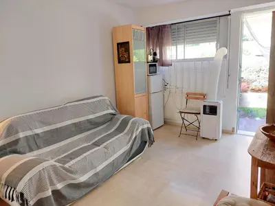a bedroom with a bed and a kitchen with a window at Studette Pointe Croisette - Axelle Loc'Appart in Cannes